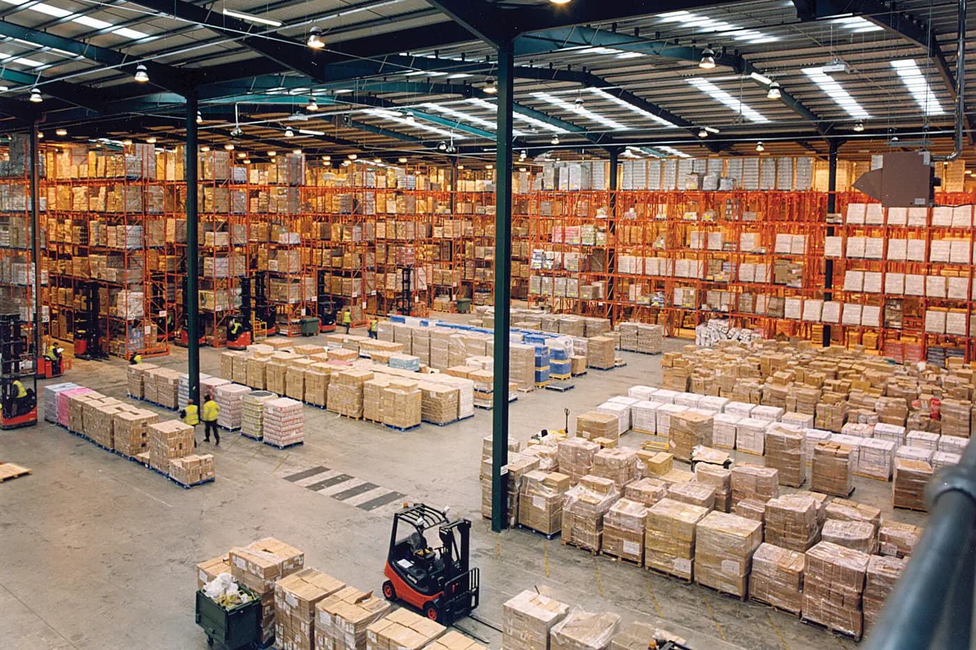 Yüksek raf sistemleri ve forklift koridorları bulunan çelik taşıyıcılı lojistik deposu