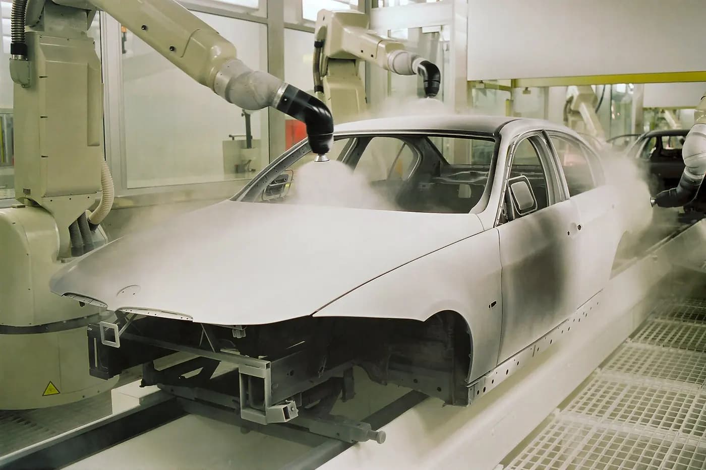 Otomotiv gövde hattında robotik boya uygulamasına hazırlanan metal araç kabuğu